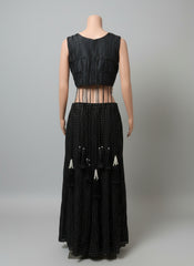 Black sleeveless top and long black skirt with bead details on a white background